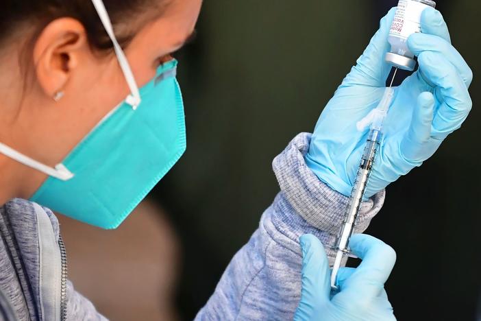 A health care worker draws a dose of Moderna's COVID-19 vaccine into a syringe for an immunization event in the parking lot of the L.A. Mission on Feb. 24.