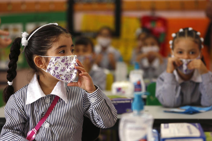 Palestinian elementary school students wearing protective face masks take their seats in their classroom amid the coronavirus pandemic on the first day of class in September at a United Nations-run school in the West Bank city of Ramallah.