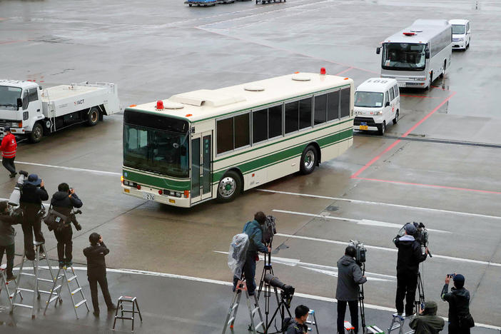 A bus believed to be carrying former U.S. special forces member Michael Taylor and his son Peter, who allegedly staged the operation to help fly former Nissan chief Carlos Ghosn out of Japan in 2019, leaves Narita International Airport in Japan on Tuesday.