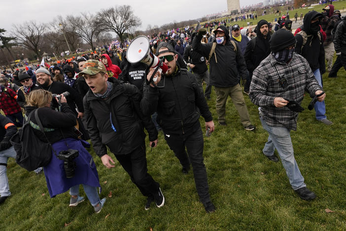 Prosecutors say Ethan Nordean, seen with a bullhorn, led members of the far-right group the Proud Boys in the Jan. 6 riot. He faces federal charges, but will be released from custody while he awaits trial.