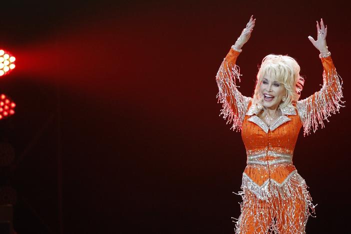 Dolly Parton, pictured performing in May 2014, shared a video of herself getting her first dose of the Moderna COVID-19 vaccine on Tuesday.