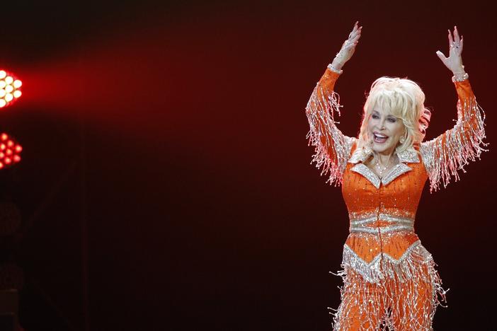 Dolly Parton, pictured performing in May 2014, shared a video of herself getting her first dose of the Moderna COVID-19 vaccine on Tuesday.