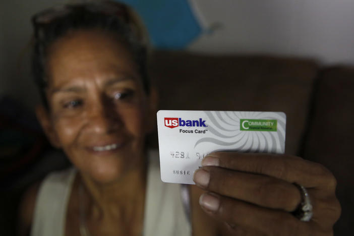 Stockton, Calif., resident Susie Garza displays the debit card on which she received a monthly stipend as part of a pilot universal basic income program. The program began in 2019, when this photo was taken.