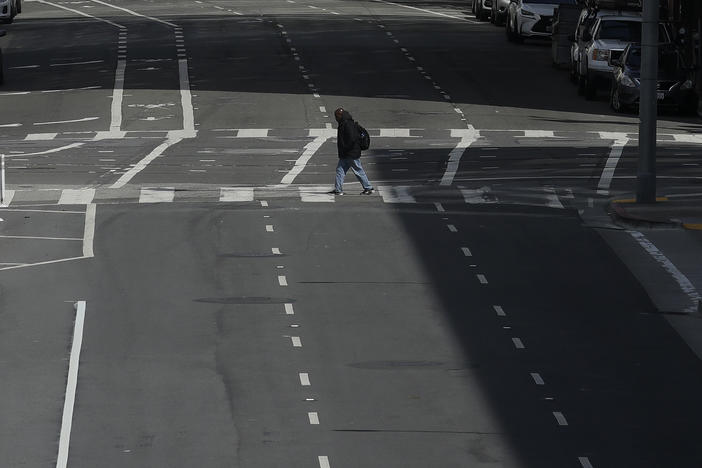 A man crosses a nearly empty street in San Francisco, on March 17, 2020. Despite a reduction in driving last year, road fatalities increased, according to the National Safety Council.