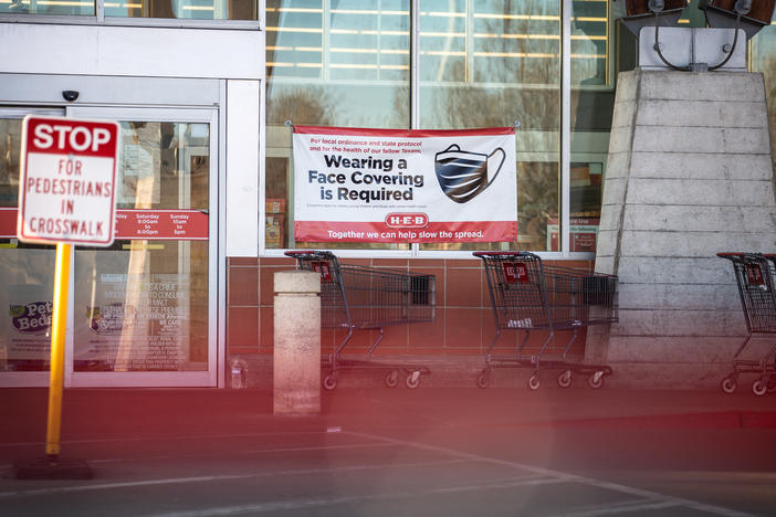 Signage requiring masks is on display outside of a H-E-B supermarket in Austin, Texas on March 3. Texas is one of the states lifting its mask mandate alongside other COVID-19 restrictions, against the warnings of public health experts.