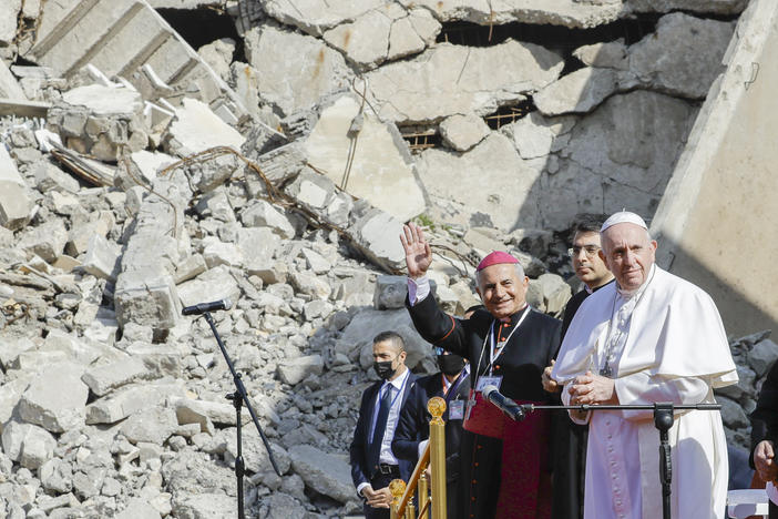 The archbishop of Mosul, Najib Mikhael Moussa (left) waves as he stands next to Pope Francis at the start of a gathering to pray for the victims of war at the Hosh al-Bieaa Church Square, in Mosul, Iraq, once the de facto capital of ISIS on Sunday.