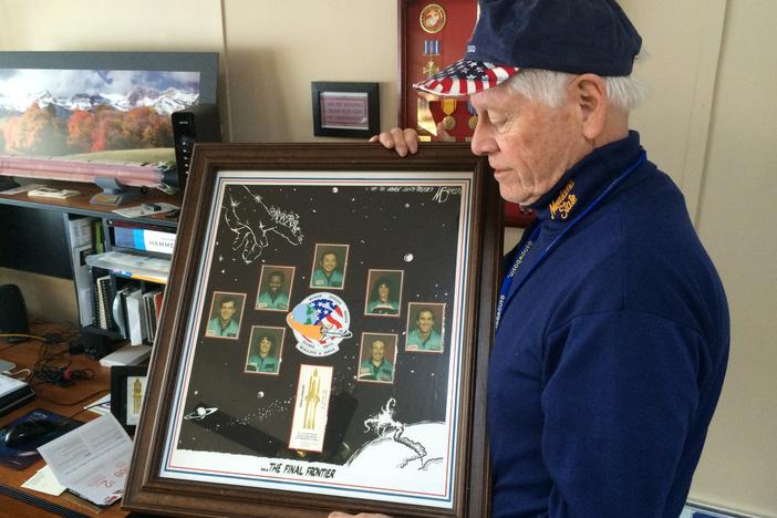 Allan McDonald in 2016 holds a commemorative poster honoring the seven astronauts killed aboard the space shuttle Challenger.