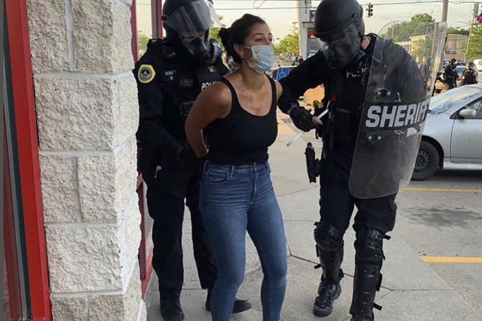 Police officers are shown arresting <em>Des Moines Register</em> reporter Andrea Sahouri after a Black Lives Matter protest she was covering on May 31, 2020, in Des Moines, Iowa. Sahouri went on trial Monday on charges of failing to disperse and interfering with official acts.