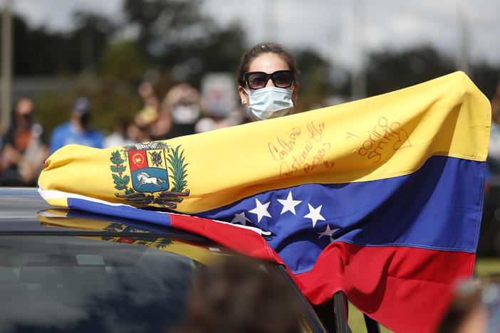 A Joe Biden supporter with a Venezuelan flag cheers during a Biden campaign event at Camping World Stadium on October 27, 2020 in Orlando, Florida.