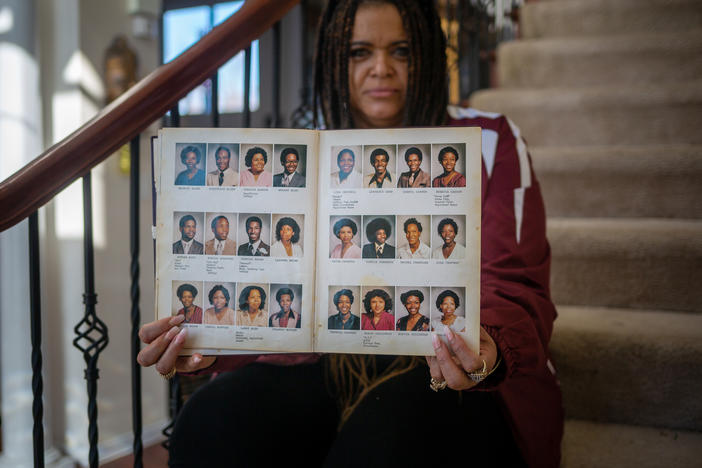 Robin Witherspoon holds up her Sumner High School senior yearbook from 1981. Alumni like Witherspoon are fighting to keep the historic school open.