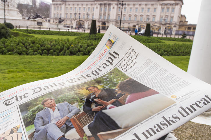 A British newspaper flutters in the wind outside Buckingham Palace in London the day after the Duke and Duchess of Sussex's interview with Oprah Winfrey.
