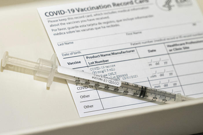 A syringe containing a dose of a Pfizer-BioNtech COVID-19 vaccine sits in a container, during a vaccine clinic at Providence Alaska Medical Center in Anchorage, Alaska. The state has become the first in the nation to offer the COVID-19 vaccine to any resident 16 or older.