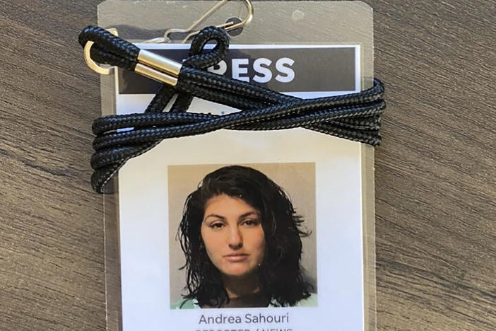 A press badge for <em>Des Moines Register</em> reporter Andrea Sahouri features the jail booking photo from her May 31 arrest while covering a Black Lives Matter protest.