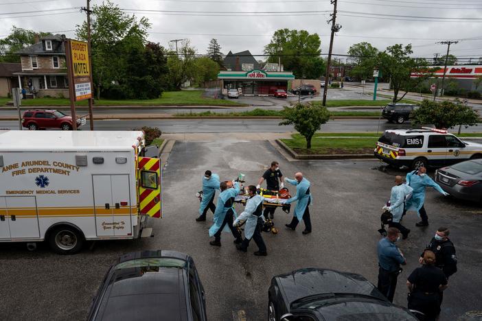 Firefighters and paramedics with the Anne Arundel County Fire Department in Maryland wear enhanced PPE, during the coronavirus pandemic, as they transport a patient after responding to a call for a cardiac arrest as a result of a drug overdose on May 6, 2020.