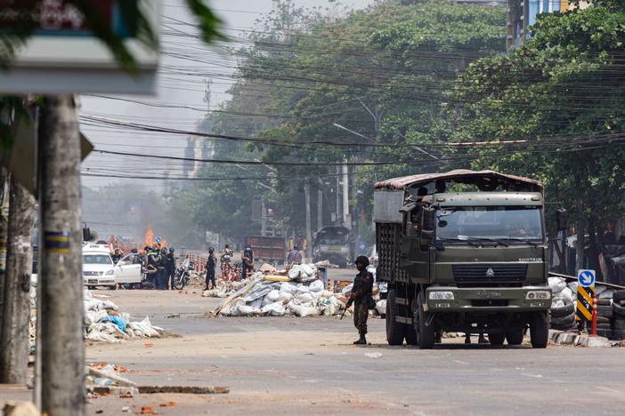 Security forces stand guard on a road as people are arrested, next to dismantled barricades that were set up by protesters demonstrating against the military coup, in Yangon, Myanmar, on Friday.