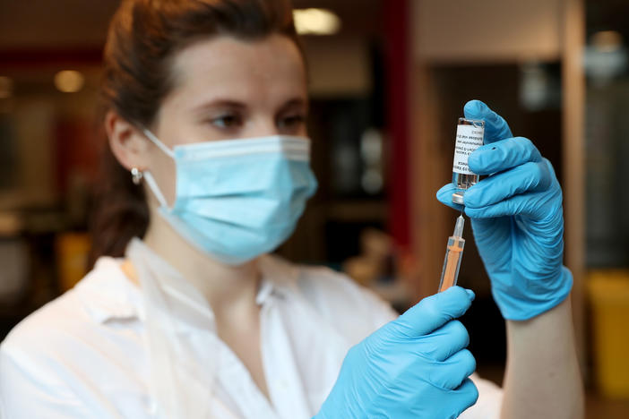 A pharmacist prepares to administer the AstraZeneca COVID-19 vaccine at a community vaccination center in London on Friday.