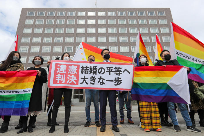 Supporters celebrate the district court's ruling on Japan's same-sex marriage ban with a flag reading "unconstitutional decision" in Sapporo, Hokkaido prefecture, on Wednesday.