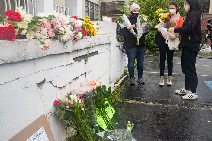 Mourners visit and leave flowers on Wednesday at the site of two shootings at spas across the street from one another in Atlanta.