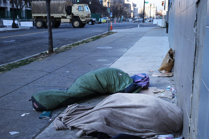 Homeless individuals sleep near a National Guard truck ahead of the inauguration of U.S. President-elect Joe Biden on Jan. 20, 2021, in Washington, D.C.