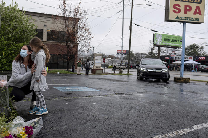 Mallory Rahman and her daughter Zara Rahman, 4, bring flowers to the Gold Spa in Atlanta on Wednesday, the day after eight people were killed at three massage spas in the Atlanta area. Authorities have arrested Robert Aaron Long, 21, in the shootings in Atlanta and Cherokee County, Ga.
