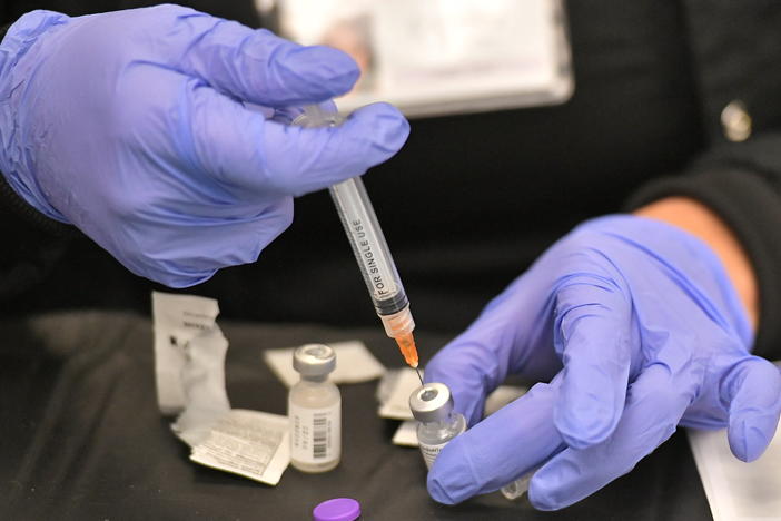 A health worker prepares a dose of the Pfizer BioNTech vaccine at a COVID-19 vaccination site at the University of Nevada in Las Vegas on March 15.