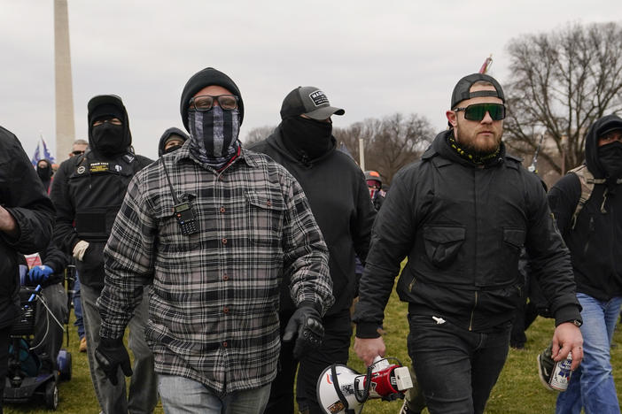 Proud Boy members Joseph Biggs (left) and Ethan Nordean, carrying a megaphone, walk toward the U.S. Capitol on Jan. 6. They were among four people indicted over conspiring to attack the Capitol.