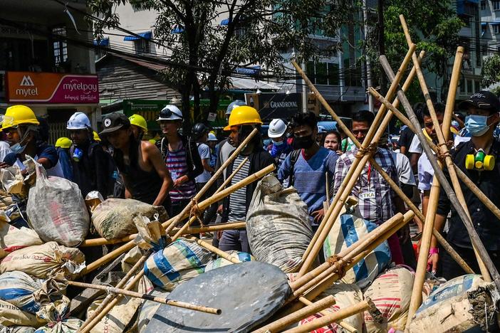 Protesters take cover behind makeshift barricades during a demonstration against the military coup in Yangon's Thaketa township on Friday.