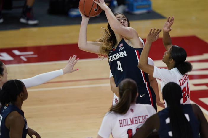 Connecticut guard Saylor Poffenbarger (4) is defended by St. John's guard Danaijah Williams (24) and forward Cecilia Holmberg (11) during the fourth quarter of an NCAA college basketball game in New York last month. The women's NCAA championship begins Sunday.