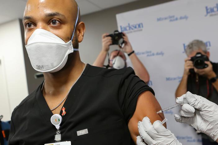 Dr. Hansel Tookes made sure his first dose of Pfizer's COVID-19 vaccine at Jackson Memorial Hospital in Miami on Dec. 15. was televised, as a way to combat hesitancy.