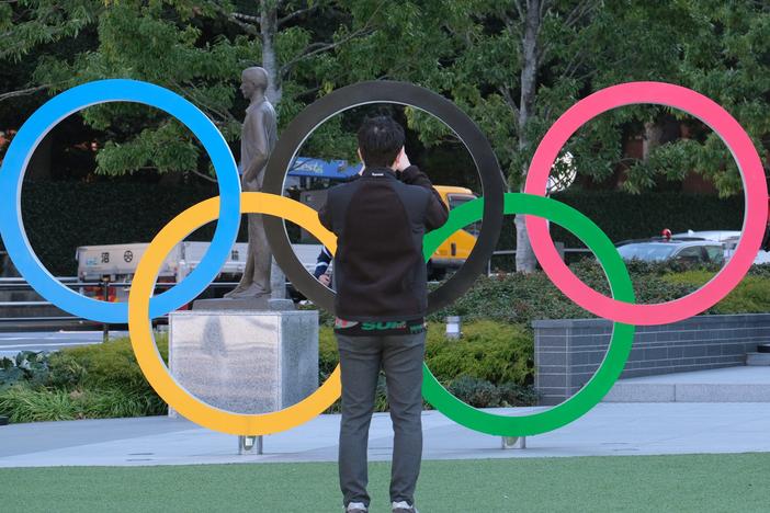 A couple takes pictures with the Olympic rings monument near the National Stadium for the Tokyo 2020 Olympic Games on Feb. 4. Organizers have decided that overseas spectators won't be allowed to attend the Games this summer.