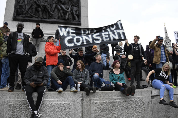 People without face masks attend a protest against government restrictions to curb the spread of the coronavirus in London on Saturday.