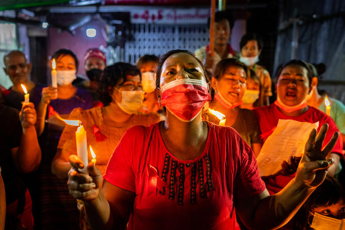 People hold candles and make a three-finger salute in a market on Feb. 5 in Yangon, Myanmar. People in Myanmar continue to take part in acts of civil disobedience in protest against the Feb. 1 military coup.