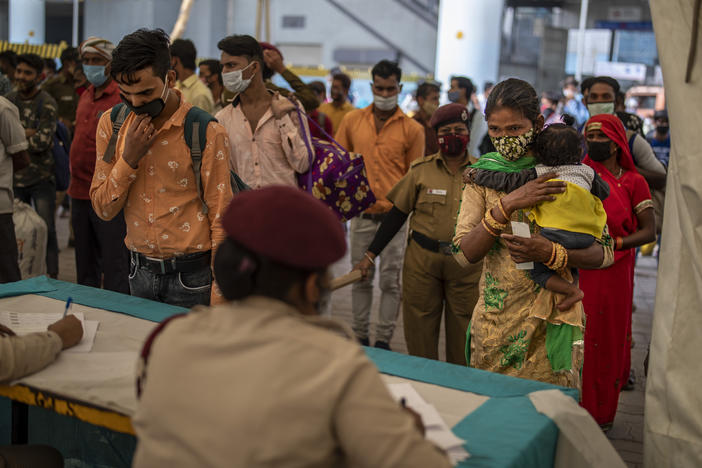 Passengers register at a counter before being tested for COVID-19 at a bus terminal on Wednesday in New Delhi.