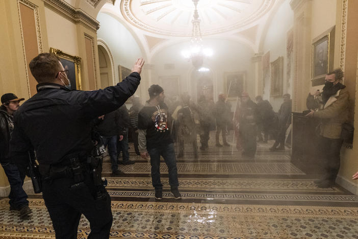 Smoke fills the walkway outside the Senate chamber as U.S. Capitol Police confront rioters inside the Capitol on Jan. 6.