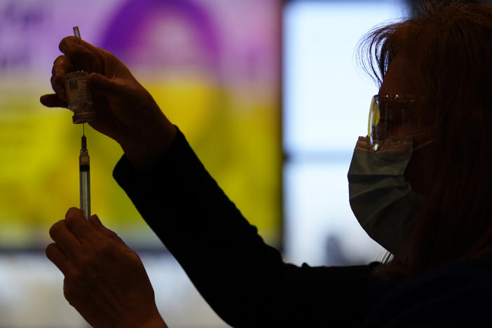 A county health worker fills a syringe with the Moderna COVID-19 vaccine in West Chester, Pa., in late December. Rutgers University will require students enrolling for the fall semester to show they have received a COVID-19 vaccine.