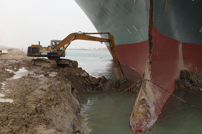 Heavy equipment is used to try to dig out the keel of the Ever Given, a massive cargo ship wedged across the Suez Canal.