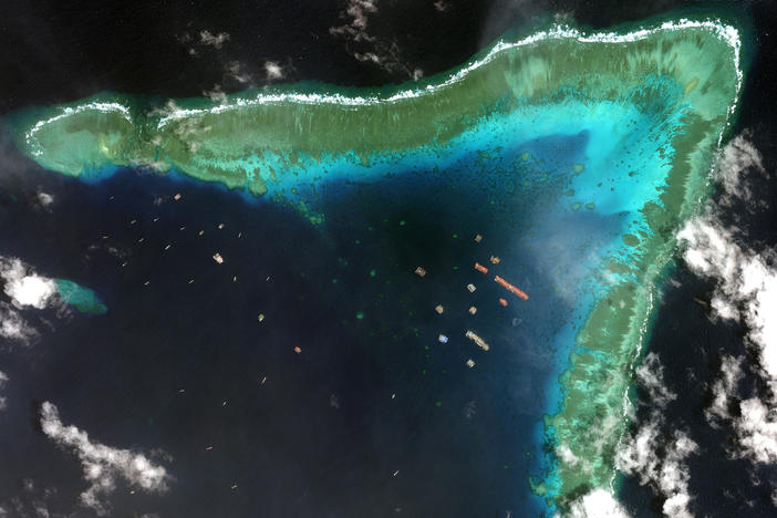 Overview of Whitsun Reef in the South China Sea and Chinese vessels moored in the waters surrounding the boomerang-shaped coral reef on March 23.