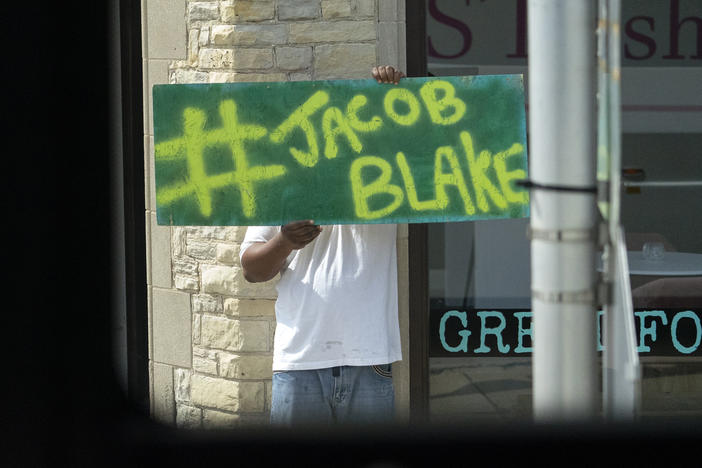 A Jacob Blake sign was on display as the motorcade of then-presidential candidate Joe Biden passed by in Kenosha Wis., on Sept. 3, 2020. A team of attorneys representing Blake have filed an excessive force lawsuit against the officer who shot and paralyzed him in August.