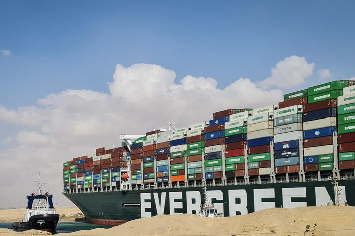 A tugboat participates in an attempt on Friday to refloat the Ever Given, a container ship that has been stuck in the Suez Canal since it ran aground on Tuesday.