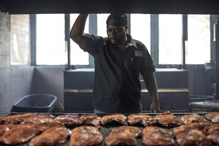Rodney Scott checks racks of ribs as they cook on July 3, 2018 in Charleston, S.C.