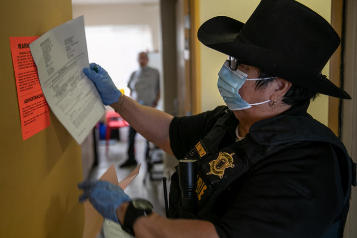 A constable posts an eviction order for nonpayment of rent in October in Phoenix. The CDC is extending an order aimed at preventing evictions.