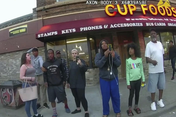 This image from a police body camera shows people gathering as former Minneapolis police officer Derek Chauvin was recorded pressing his knee on George Floyd's neck for several minutes as onlookers yelled at Chauvin to get off and Floyd said that he couldn't breathe on May 25, 2020 in Minneapolis.