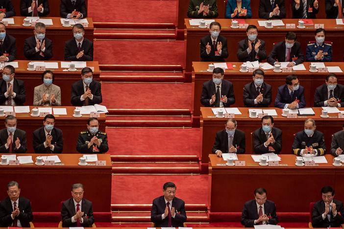 China's President Xi Jinping (C) applauds with other leaders and delegates after they voted on changes to Hong Kong's election system during the closing session of the National People's Congress at the Great Hall of the People in Beijing on March 11, 2021.