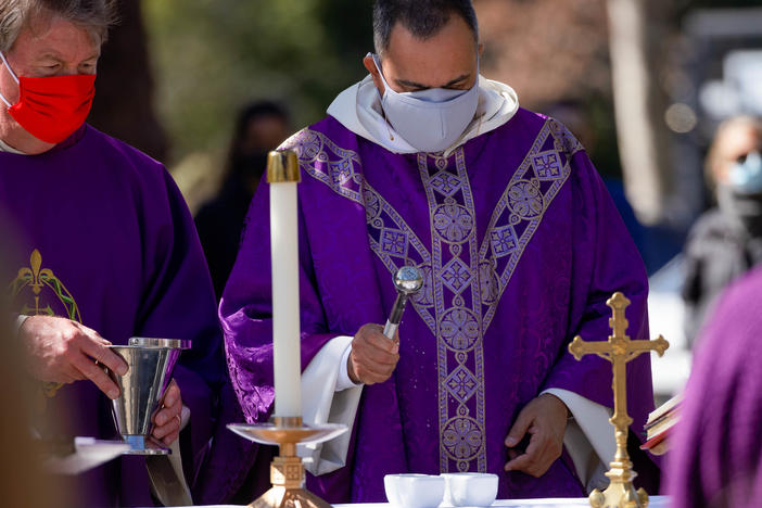 The Rev. Michael Amabisco blesses ashes during an Ash Wednesday service at St. Raymond Catholic Church in Menlo Park, Calif., in February. A new Gallup survey finds that those professing church membership has fallen 18 percentage points among Catholics since 2000.
