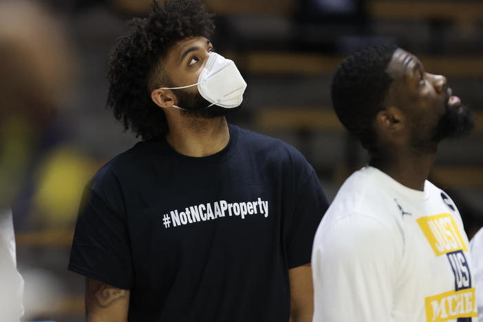 Wearing a shirt that says, "#NotNCAAProperty," injured University of Michigan basketball player Isaiah Livers looks on prior to his team's NCAA tournament game against Texas Southern on March 20. On Wednesday the U.S. Supreme Court hears a case testing the NCAA's limits on compensation for student athletes.
