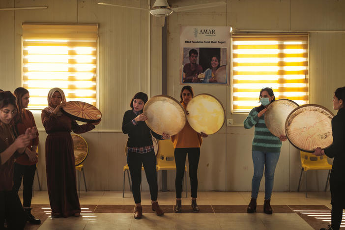 Rana Sulaiman Halo (center), performs with a traditional <em>daf</em> drum with the Ashti (Peace) Choir.