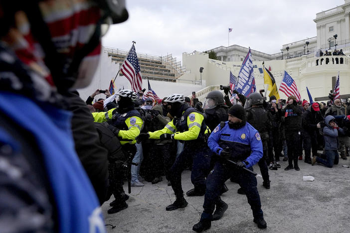 Police officers try to push back President Donald Trump supporters trying to break through a police barrier, Jan. 6 at the Capitol in Washington. Two U.S. Capitol police officers have sued Trump for allegedly inciting the mob that attacked them that day.