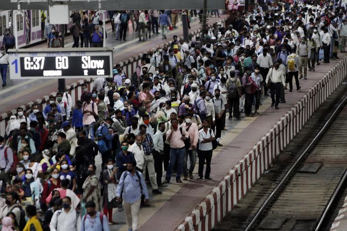 Commuters wait to board a suburban train on Tuesday at Chhatrapati Shivaji Maharaj Terminus prior to the night curfew that has been introduced to curb the spread of COVID-19 in Mumbai.