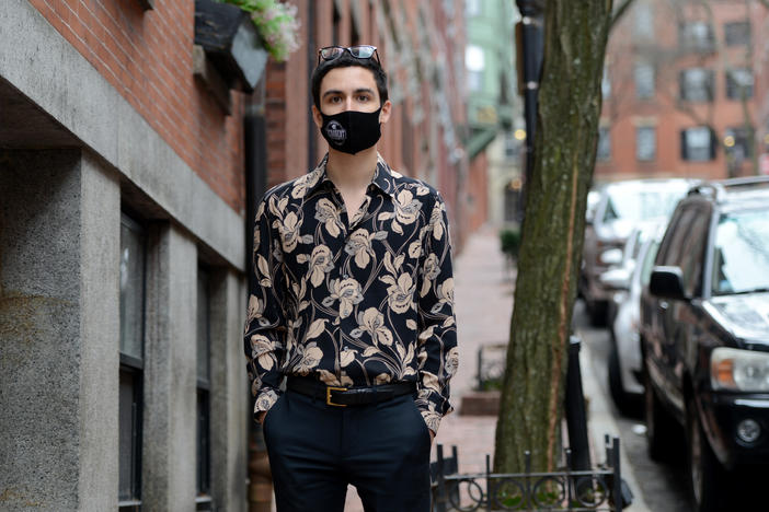 Gabriel Toro, 23, stands on the sidewalk near his apartment in Boston on March 11. Toro completed the credits required for a bachelor's degree from the University of Massachusetts Boston but the school wouldn't release Toro's transcript or degree because of an unpaid balance.