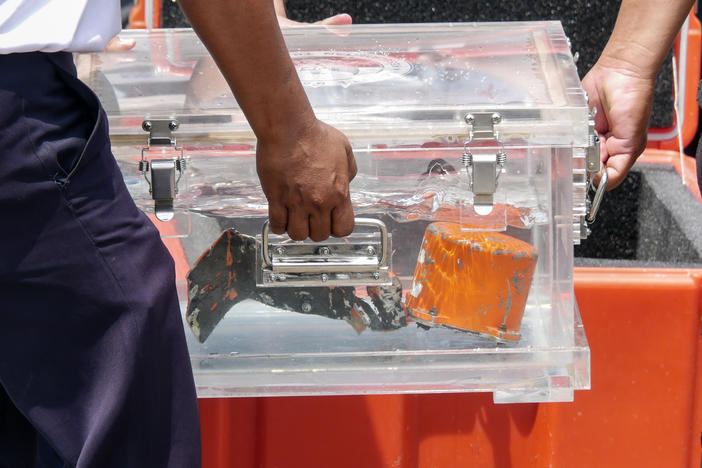 Indonesia's National Transportation Safety Committee (KNKT) officers carry the memory unit from a cockpit voice recorder recovered from the crashed Sriwijaya Air Flight SJ 182 at Tanjung Priok Port in Jakarta on Wednesday.